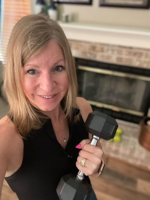 Nicky posing with a weight in her living room.